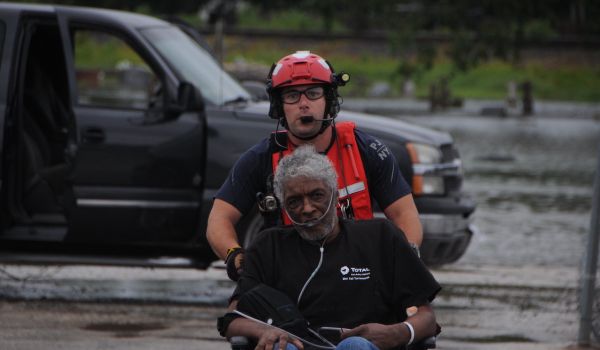 A pararescueman assigned to the New York Air National Guard pushes an elderly man toward the HH-60 Pave Hawk helicopter in Houston area, August 30, 2017.