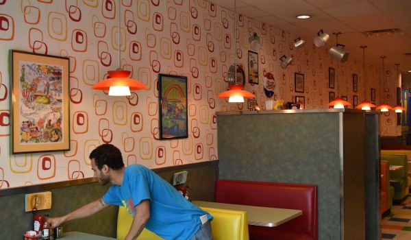 Worker adjust condiments on diner table