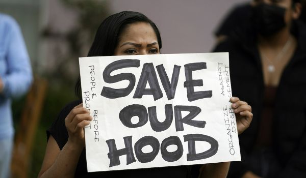 A tenant holds a sign reading